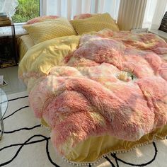 a bed covered in pink and yellow blankets