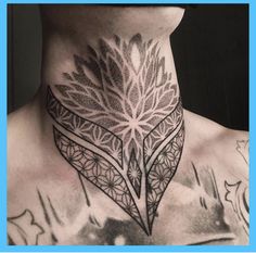 a man's neck is adorned with an intricate tattoo design and has flowers on it