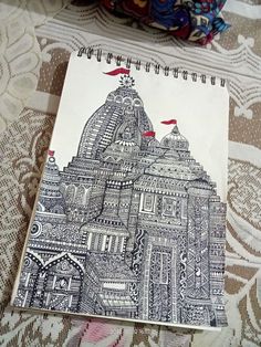 a notebook with a drawing of a building on it