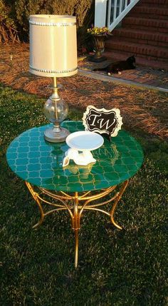 a table with a lamp on it in the grass