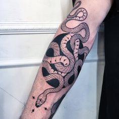 a man's arm with a snake tattoo on it