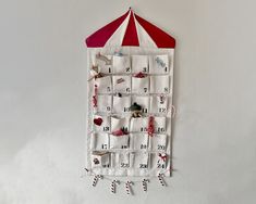 a red and white umbrella hanging from the side of a wall with calendars on it