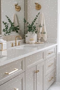 a bathroom with two sinks and gold faucets