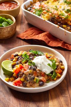 two plates of mexican food on a wooden table