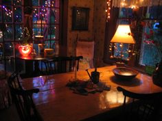 a dining room table with lights on the windows