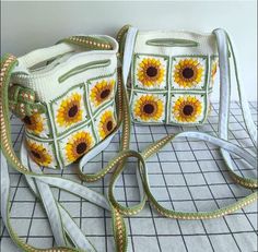 two purses with sunflowers on them sitting next to each other