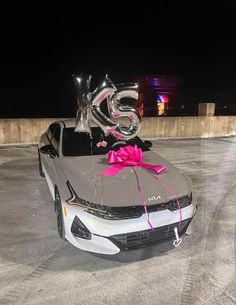 a silver car with a pink bow and number 25 on it