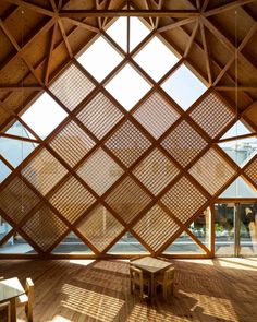 the inside of a wooden building with lots of windows and wood flooring on it