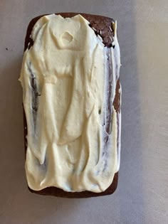 a piece of chocolate cake with white frosting on it sitting on top of a table