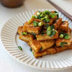 tofu on a white plate with chopsticks next to it