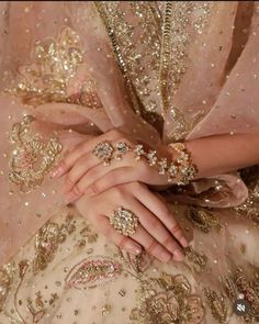 a close up of a person's hands wearing jewelry