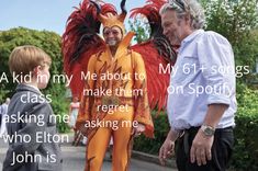 two men are talking to each other in front of a man with an orange costume