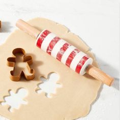 cookie cutters and gingerbread cookies on a table with icing, sugar and candy canes