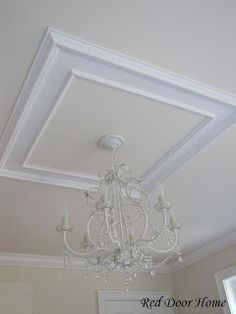 a chandelier hanging from the ceiling in a room with white walls and ceilings