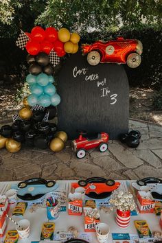 a table topped with lots of food and balloons