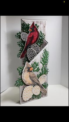 a card with a cardinal and pineconi on it, in front of a white background