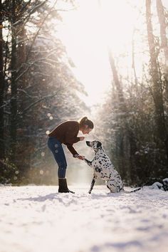 a woman playing with her dog in the snow