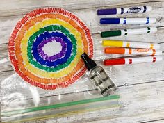 some crayons and markers are sitting on a table next to a paper plate