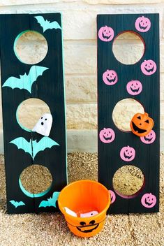 two halloween decorations made out of wood and decorated with pumpkins