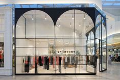 the inside of a clothing store with glass walls