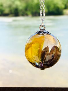 This is a handcrafted yellow flower terrarium resin bubble necklace! I created this pendant with a yellow dried wildflower, tree pieces, and real moss. This will make a great addition to your collection or as a special gift. This pendant includes an 18- or 20-inch sterling silver plated chain or a 20-inch stainless 20-inch chain! (Please choose your chain choice at checkout) Gift ideas include (Mother's Day gift, bridal shower gift, bridesmaid jewelry, Valentine's Day gift, birthday gifts, grand Nature-inspired Yellow Necklace For Gifts, Yellow Nature-inspired Necklace For Gifts, Resin Necklace With Natural Inclusions, Nature-inspired Resin Necklaces With Round Pendant, Nature-inspired Resin Necklace With Round Pendant, Nature-inspired Resin Round Pendant Necklaces, Nature-inspired Resin Round Pendant Necklace, Flower Terrarium, Epoxy Resin Necklace