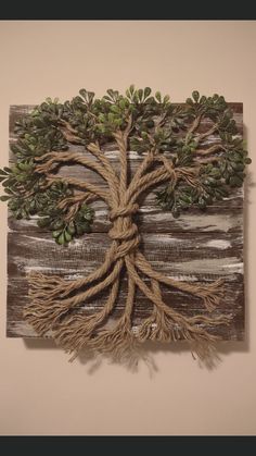 a wall hanging with a tree made out of rope and some green leaves on it