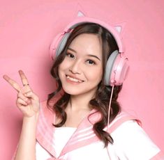 a young woman wearing headphones and pointing to the side with her finger in front of her face