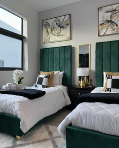 two beds in a room with green headboards and white sheets, one has black and gold pillows