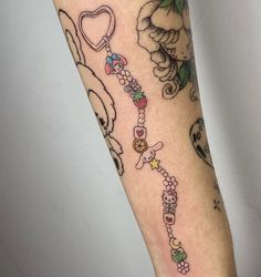 a person with a tattoo on their arm has a dog and heart bracelet attached to it