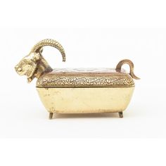 a goat head sitting on top of a white box with gold trim around it's neck