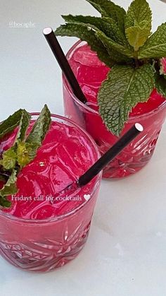 two glasses filled with pink liquid and green leaves