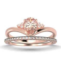 an engagement ring set with a pink diamond in the center and two white diamonds on each band