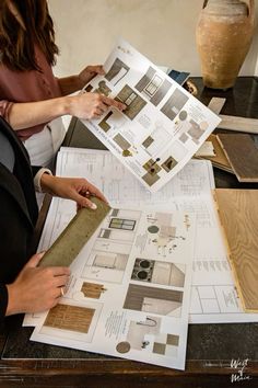 two women are working on some architectural drawings