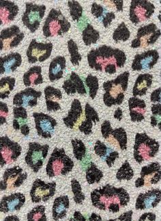 an animal print fabric with black, pink, green and blue spots on the side