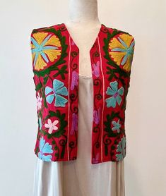 Work of Art! Suzani Embroidered Vest. This Suzani Vest is For Suzani Lover. Suzani vest with multi color stitching. Suzani is a type of artisan embroidery done in loops. When you look closely, you will see how the loops are designed and how a pattern is formed. This vest is one-of a-kind, repurposed using the artisan stitching. The love of Suzani is based on the concept that each pattern is different and people admire the stitching, setting you apart from the crowd. Beautiful and balanced fashion piece. Only one available.Vests are an essential wardrobe accessory this fall and winter. Our vests are the best in the market incorporating a multitude of colors. Pair your vests with a sweater, T-shirt, or a crisp white shirt over slacks, jeans, skirts, and even one piece dresses. This will beco Bohemian Multicolor Embroidered Nehru Jacket, Spring Bohemian Fitted Nehru Jacket, Bohemian Multicolor Vest With Floral Embroidery, Multicolor Floral Embroidery Nehru Jacket For Spring, Multicolor Bohemian Vest With Floral Embroidery, Bohemian Multicolor Floral Embroidered Vest, Bohemian Multicolor Nehru Jacket For Spring, Embroidered Sleeveless Nehru Jacket For Spring, Festive Spring Vest With Embroidery