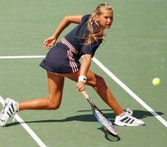 a woman is running to hit the tennis ball with her racket on the court