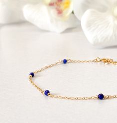 This beautifully simple bracelet is lovingly handmade with a six tiny Lapis Lazuli gemstones and a choice of 14k Gold Filled, 14k Rose Gold Filled or Sterling Silver Chain. M A T E R I A L S: * Lapis Lazuli * 14k Gold Filled, 14k Rose Gold Filled or Sterling Silver Chain S I Z E: *  Gemstones - Approximately 2-3mm *  Chain Thickness - Approximately 1.1mm  All of our jewellery is carefully handmade using good quality materials and handpicked gemstones, with the aim to produce quality pieces that you can love & wear for years to come.  L A P I S  L A Z U L I: * September Birthstone * Talisman for Taurus, Virgo, Libra, Sagittarius * Throat Chakra, Third Eye Chakra A stone of protection, Lapis Lazuli quickly releases stress, bringing deep peace. It brings harmony and deep inner self-knowledge. Tiny Beads Bracelet Jewelry Gift, Dainty Chain Bracelet With Tiny Beads As Gift, Elegant Blue Chain Bracelet As Gift, Elegant Blue Chain Bracelet For Gift, Dainty Chain Bracelet With Tiny Beads For Gift, Adjustable Blue Jewelry With Delicate Chain, Elegant Blue Bracelet With Delicate Chain, 14k Gold Filled Jewelry With Tiny Beads For Gifts, Delicate Bracelet Jewelry With Tiny Beads