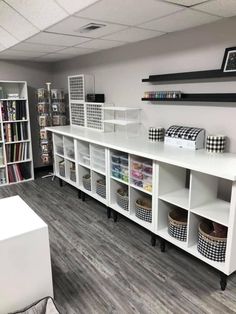 a room filled with lots of white shelves and bins