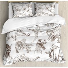 an image of a bed with dinosaurs printed on the comforter and pillowcases