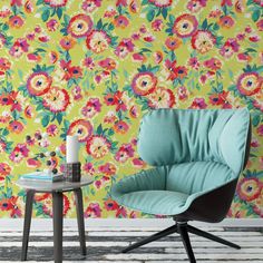 a chair and table in front of a wallpapered room with flowers on it