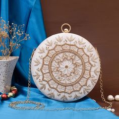 Designer Embroidered Round Clutch Size :- 8 x 8 inch DESIGN: Embellished with Indian hand work, the soft fabric interior of the evening bag has enough room to keep your credit card, cash, and other small essentials like mobile phones, lipstick, highlighter, keys. OCCASION: These women's evening handbags are perfect to match your dresses or shoes on your wedding, birthday, party, prom night, date night, Christmas or any formal or informal event where you want to make heads turn. GIFT: Absolutely White Clutch Purse, Crystal Embroidery, Potli Bag, Silk Gifts, White Clutch, Gold Clutch, Potli Bags, Bridal Clutch, Designer Clutch