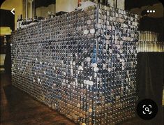 a large stack of beer cans sitting on top of a wooden floor