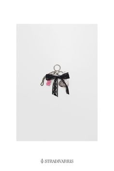 a keychain with a black and pink ribbon hanging from it's side