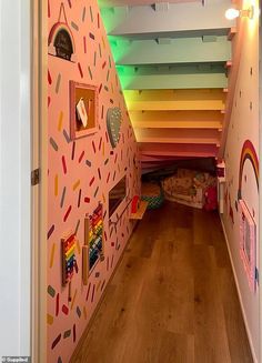 the hallway is decorated with colorful wallpaper and pictures on the walls, along with wooden flooring