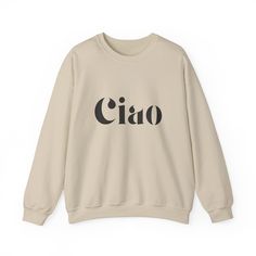 Stay warm and stylish with the Ciao Sweatshirt! The ribbed collar and medium-heavy fabric blend of cotton and polyester provide ultimate coziness. No more itchy side seams, thanks to the tear-away label. Available in sand, gray, or white from Gildan. Made using 100% ethically grown US cotton. Gildan is also a proud member of the US Cotton Trust Protocol ensuring ethical and sustainable means of production. The blank shirt's dyes are OEKO-TEX-certified dyes with low environmental impact. Fabric b Beige Letter Print Sweatshirt For Fall, Beige Cotton Sweatshirt With Letter Print, Beige Cotton Sweater With Letter Print, Beige Letter Print Sweatshirt For Loungewear, Beige Cotton Sweatshirt For Streetwear, Trendy Cream Cotton Sweatshirt, Cream Cotton Trendy Sweatshirt, Winter Cream Sweater With Letter Print, Cream Winter Sweater With Letter Print