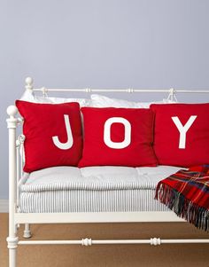 a white day bed with red and white pillows