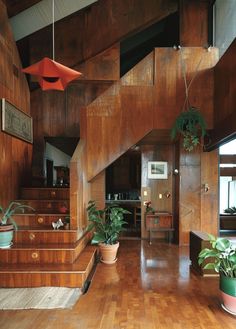 the interior of a house with wooden stairs and plants in potted planters on either side of the staircase