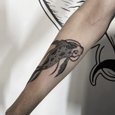 a man's arm with a fish tattoo on it