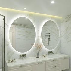 a bathroom with two sinks and three round mirrors on the wall above them is illuminated by recessed lights