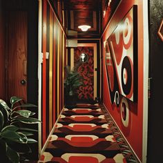 the hallway is decorated with red, black and white geometric designs on the walls next to a potted plant